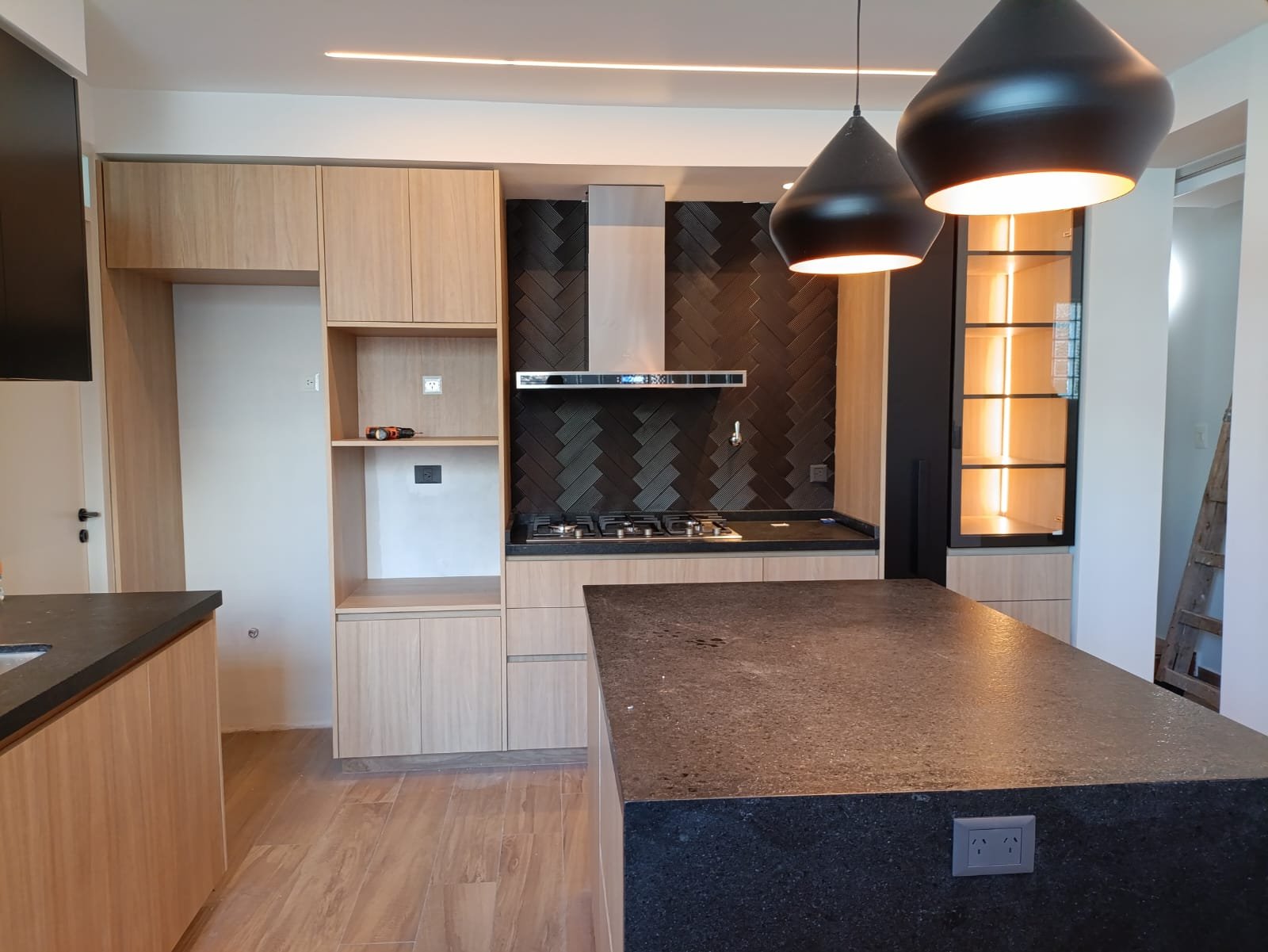 Cozinha escandinava moderna com ilha de madeira e pedra preta — projeto Belgrano, por Licefe Carpentry SRL, em Belgrano